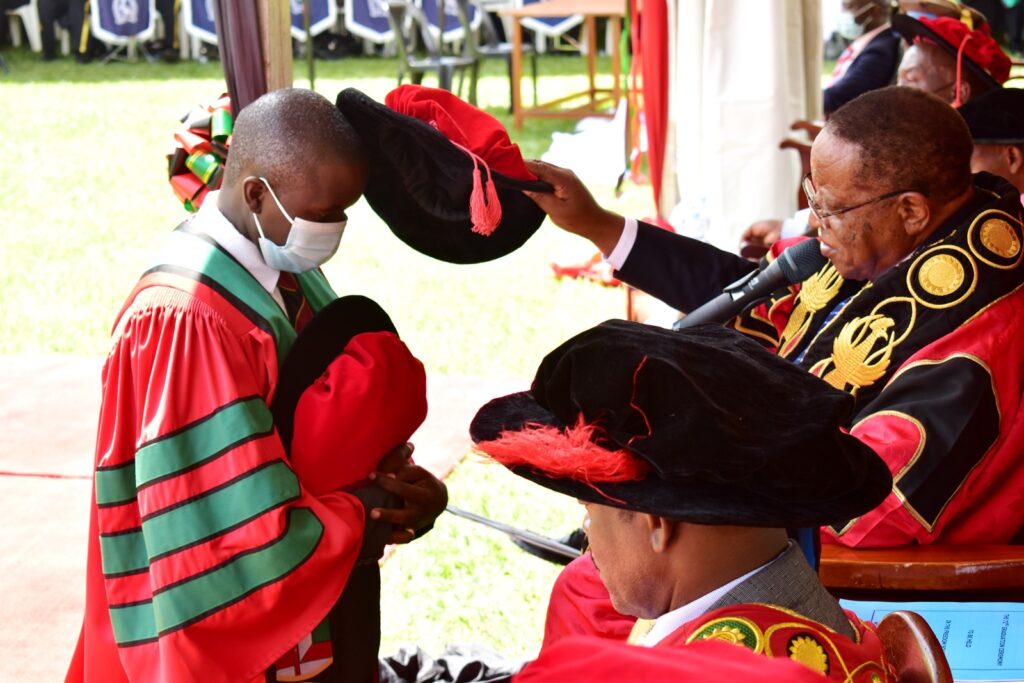 Dr. Godwin Anywar (L) receiving his doctorate from the Chancellor, Prof. Ezra Suruma (R)