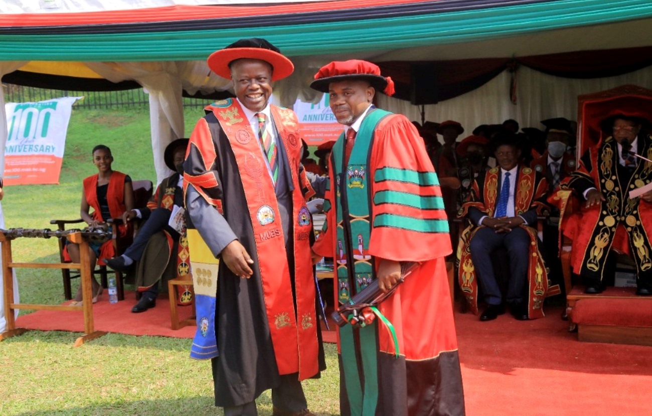 The MUBS Principal, Prof. Waswa Balunywa (L) shares a light moment with PhD Graduand Kushemererwa Christopher (R) shortly after he received his award during the Fourth Session of Makerere University's 72nd Graduation Ceremony on 26th May 2022. Photo: Twitter/@OfficialMUBS
