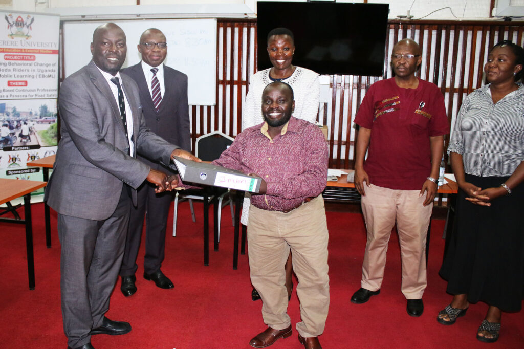 Front Row: Outgoing Director, Dr. Godfrey Mayende (2nd L) hands over to Incoming Director, Prof. Paul Muyinda Birevu (Left) the Directorship of IoDEL.