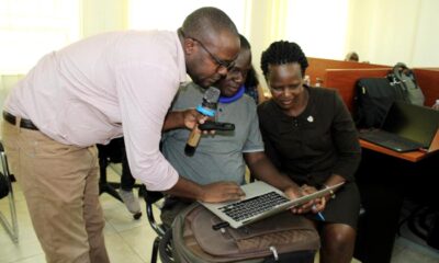 Dr. Jjingo Caeser (L) and another instructor (R) helping the student (C) during hands-on training on 16th May 2022, CHUSS Smart Room, Makerere University.