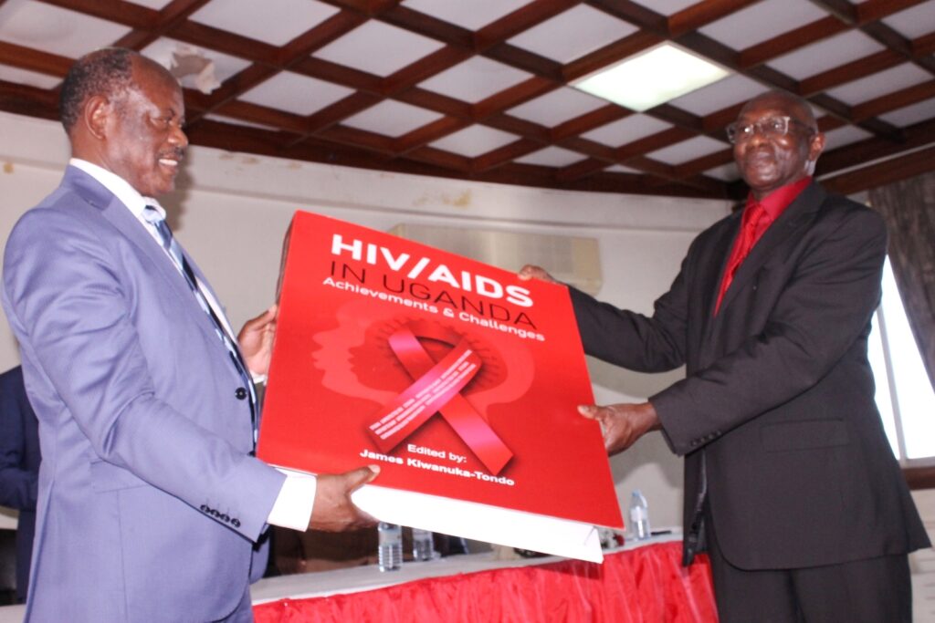 Prof. Barnabas Nawangwe (L) receives a dummy of the book from Prof. James Kiwanuka-Tondo (R) shortly after he officially launched it.