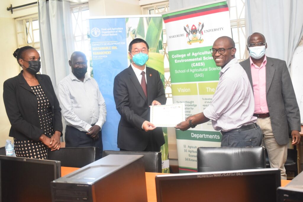 One of the participants in the Digital Soil Mapping training receives a certificate of participation from the First Secretary, Embassy of China in Uganda, Mr Chenxu Wang.