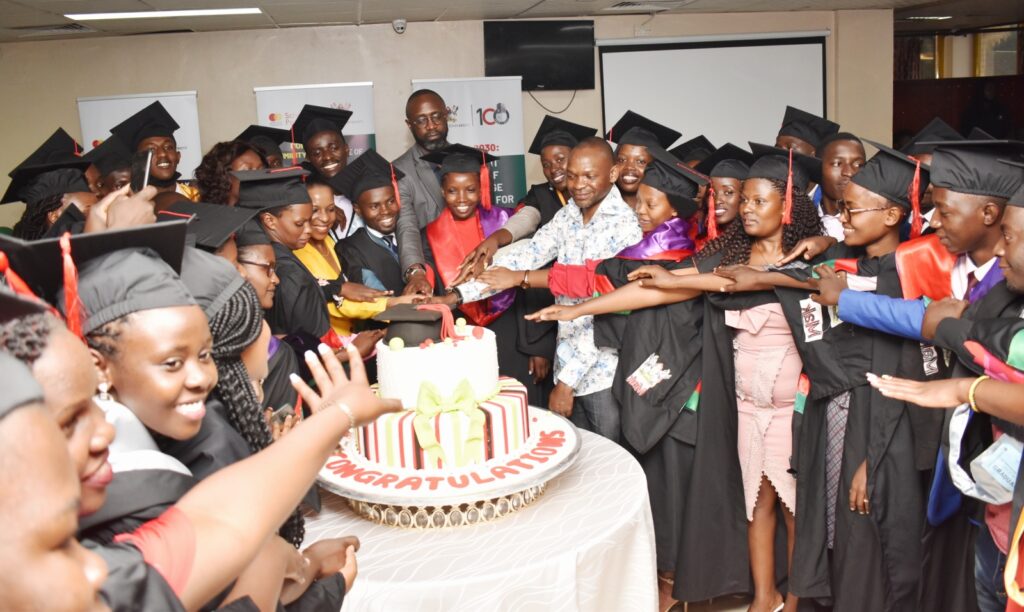 Graduates join Dr. Ruth Biyinzika Musoke, Prof. Umar Kakumba and Mr. Adrian Bukenya in the cake cutting ceremony.