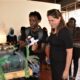 Amy Petersen, the Cultural Affairs Officer, US Embassy Uganda listens to one of the exhibitors during the official opening of the exhibition on 20th July 2022, Makerere Art Gallery.