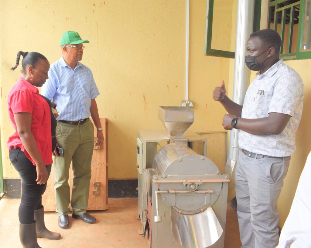 Dr. Tonny Obua (R) explains to the Principal how the Soybean roaster operates.