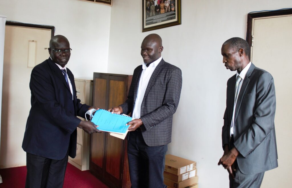 The Principal CEES-Prof. Anthony Muwagga Mugagga (R) witnesses as Outgoing Head, Department of Adult and Community Education (DACE)-Dr. Willy Ngaka (L) hands over to Incoming Head, DACE-Dr. Rahman Sanya (C) on 30th June 2022.