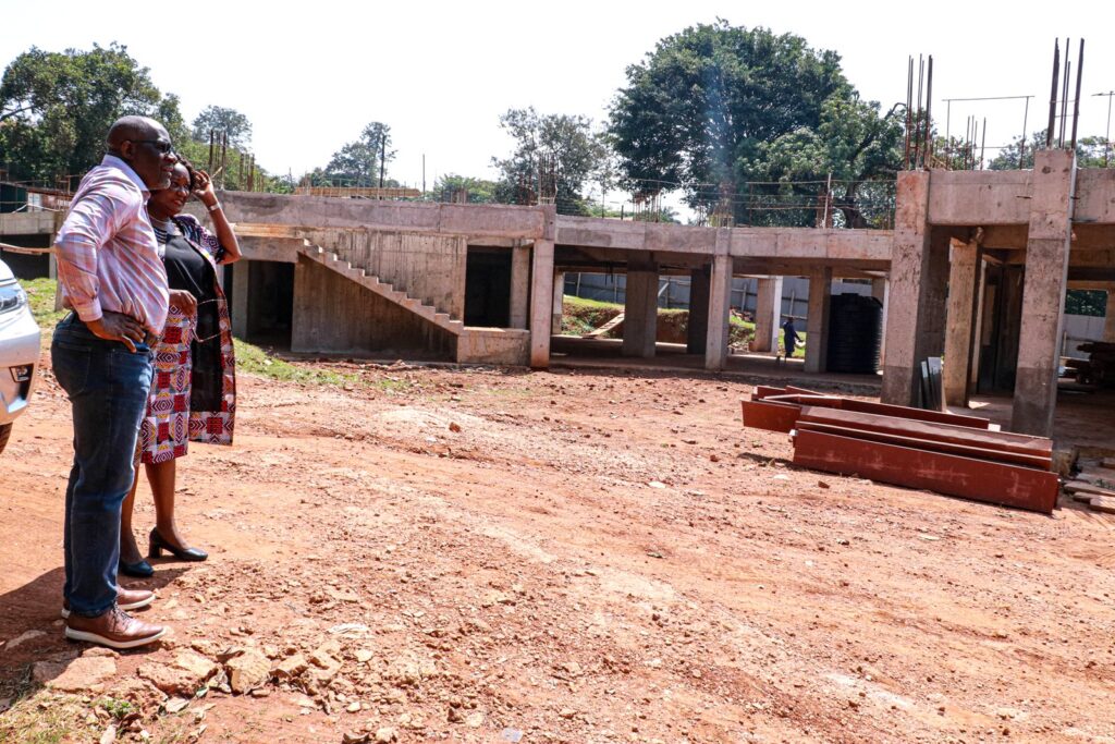 Dean MakSPH, Prof. Wanyenze (2nd L) shows Dr. Sambisa (L) another angle of the MakSPH building under construction at the Main Campus, Makerere University. 