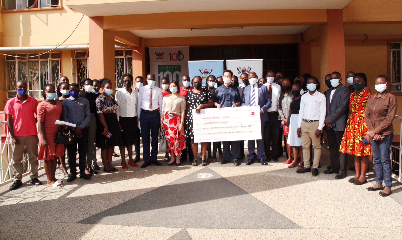 L-R: (Holding the dummy cheque) Dr. Euzobia Baine Mugisha-Director Gender Mainstreaming Directorate, H.E. Zhang Lizhong-Ambassador of People's Republic of China to Uganda and the Vice Chancellor Prof. Barnabas Nawangwe in a group photo with the scholars and some members of staff on 26th July 2022 at Senate Building, Makerere University.