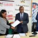 The Principal CoBAMS, Prof. Eria Hisali (C) and ACCA Uganda Country Manager, Ms. Charlotte Kukunda (L) exchange the signed agreement as the Dean School of Business, Prof. Godfrey Akileng (R) applauds on 18th July 2022, Makerere University.