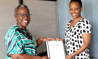 Dr. Evelyn Kigozi Kahiigi (L) handing over the report to Dr. Fiona Tulinayo Penlope (R) in the Office of the Head, Department of Information Technology on 27th July 2022, CoCIS Block A, Makerere University.