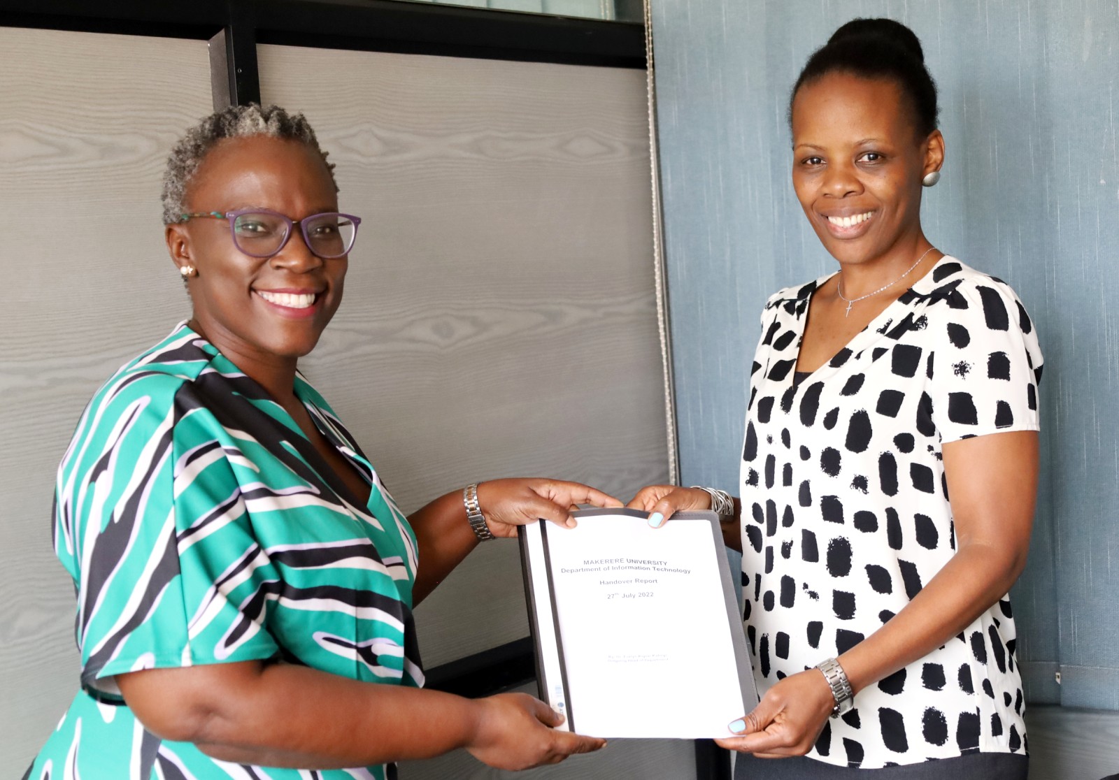 Dr. Evelyn Kigozi Kahiigi (L) handing over the report to Dr. Fiona Tulinayo Penlope (R) in the Office of the Head, Department of Information Technology on 27th July 2022, CoCIS Block A, Makerere University.