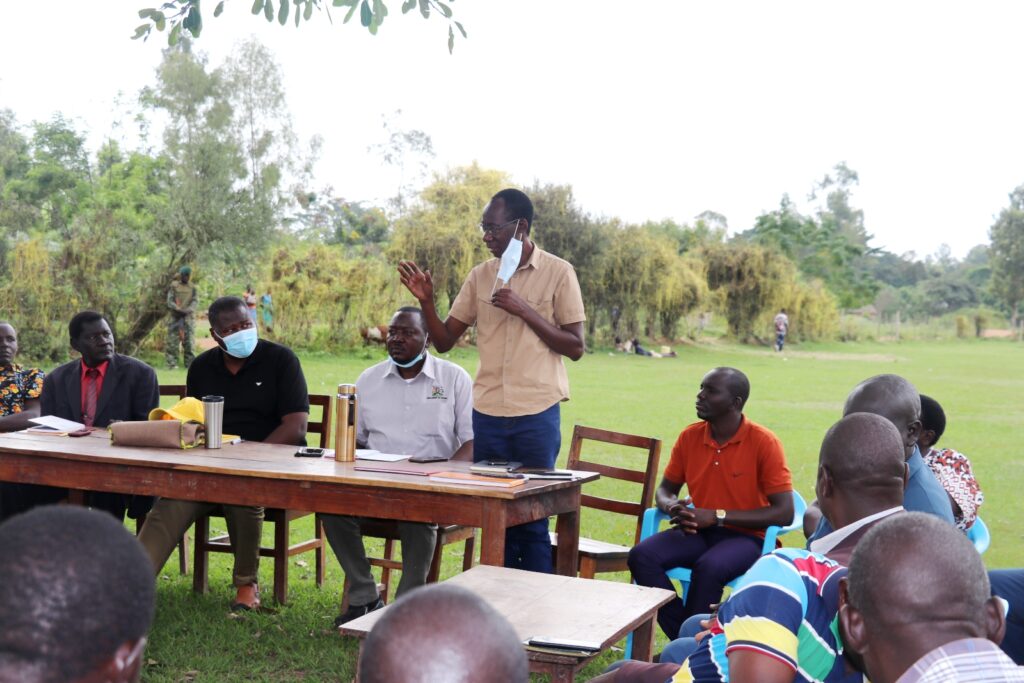 Hon. Max Ochai, Member of Parliament, representing West Budama North Constituency (standing) making his remarks during a PDM sensitization and mobilization meeting in Gule Parish, Magola, Tororo District on 25th June, 2022. To his left is Hon. Dr. Emmanuel Otiam Otala, Member of Parliament representing West Budama South Constituency, Tororo District, and the Minister of State for Defence, Hon. Jacob Marksons Oboth-Oboth (2nd left). To his right is AFRISA’s Executive Director, Mr. Felix Okello.