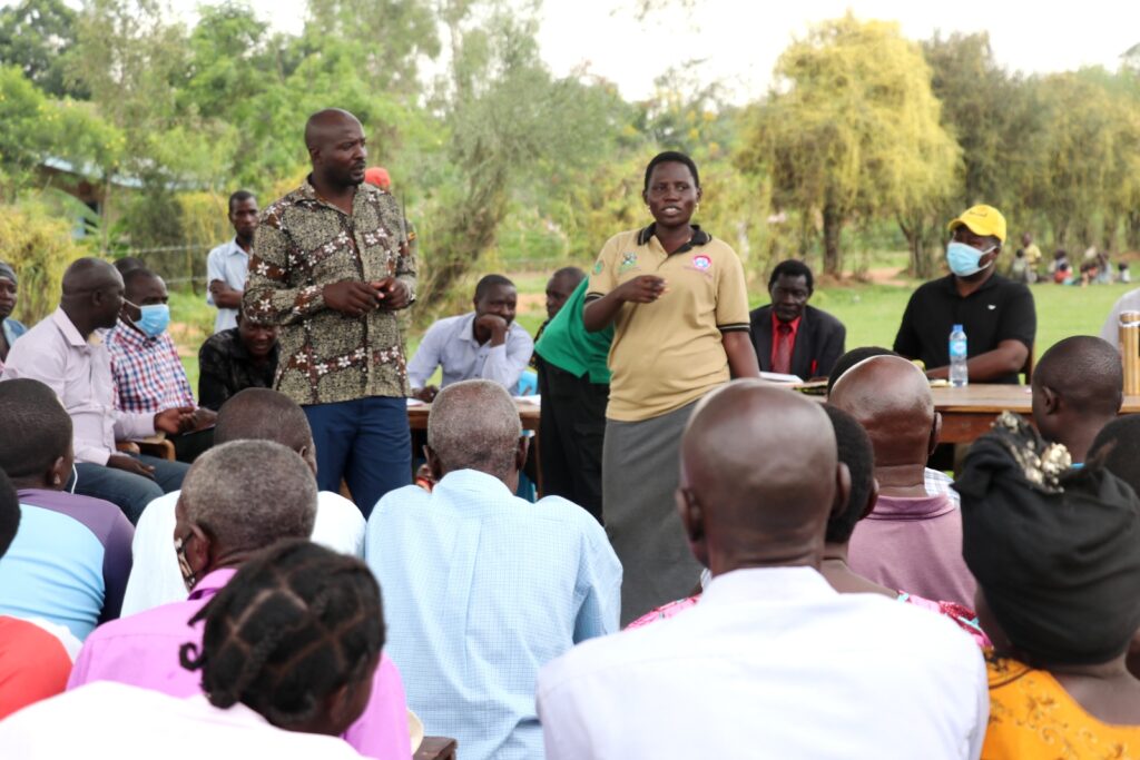 AFRISA’s Programme Officer for the Poultry Value Chain, Ms. Joyna Ofungi (Standing-Right) sensitizing the community on productivity acceleration of households during a PDM sensitization and mobilization meeting in Gule Parish, Magola, Tororo District on 25th June, 2022.