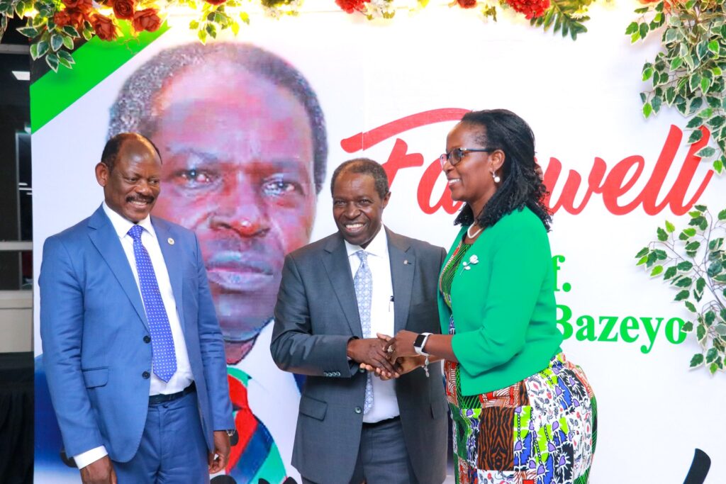 Mrs. Lorna Magara, the Makerere University Council Chairperson congratulates Bazeyo on his contribution to Makerere University as VC Prof. Nawangwe looks on.