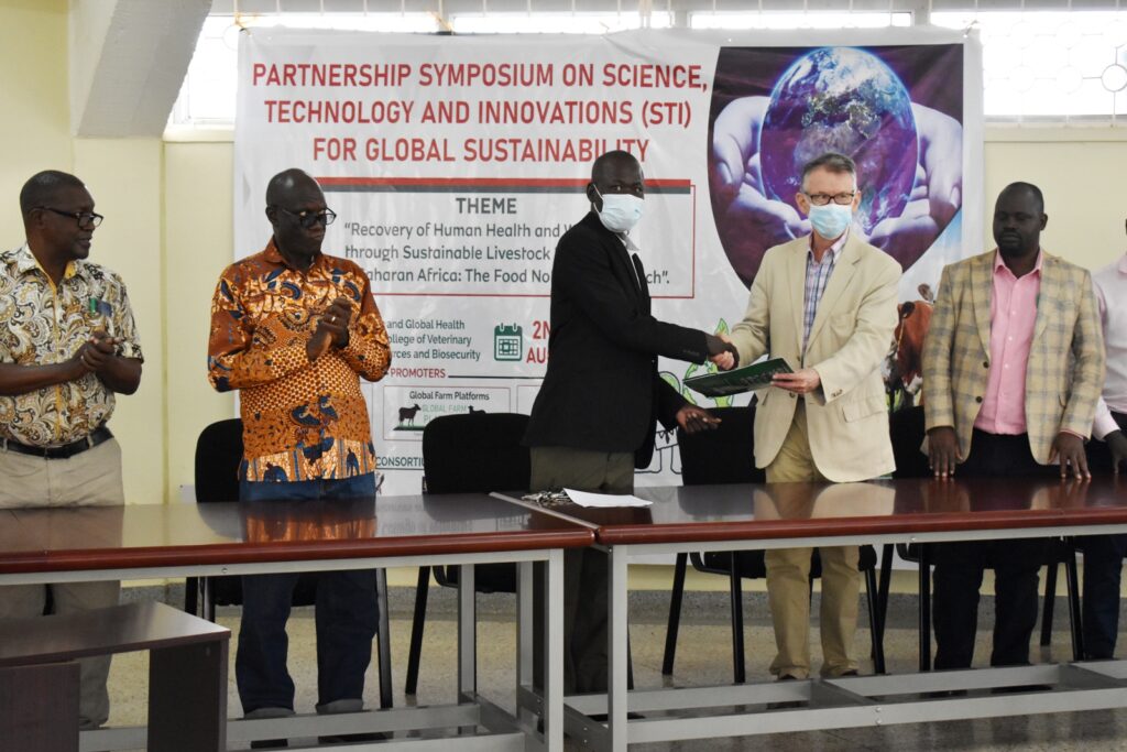 The Deputy Principal CoVAB, Prof.  James Okwee Acai (Centre) exchanges the signed declaration of intent with Prof. Mark Eisler from Bristol University (2nd Right).