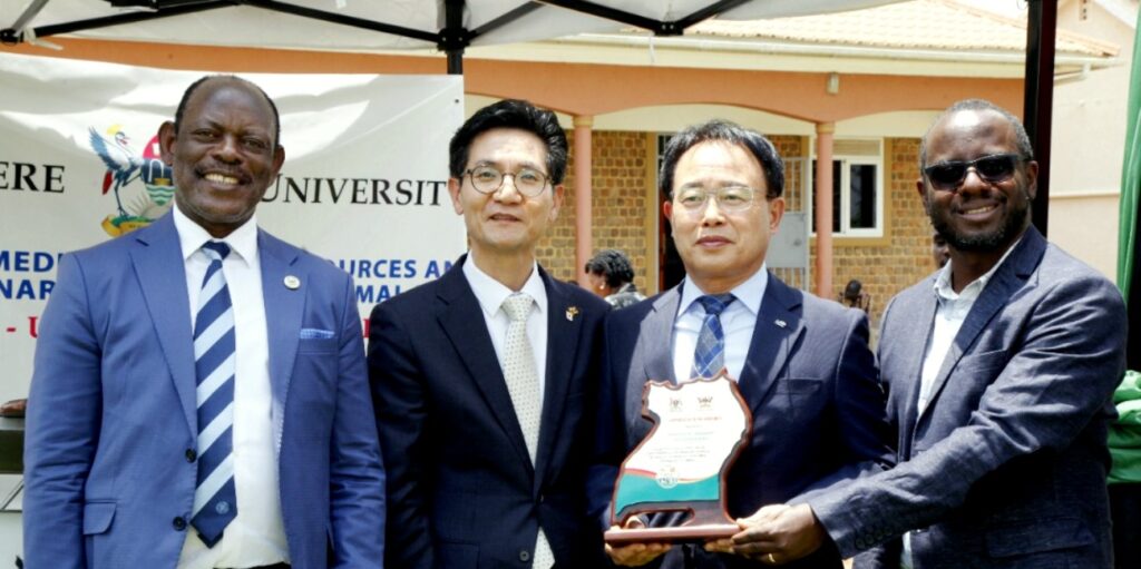 Counsel Innocent Kihika (R) presents an appreciation award to Hon. KIM Byung-Soo (2nd R) as H.E. PARK Sung-Soo (2nd L) and Prof. Barnabas Nawangwe (L) witness.