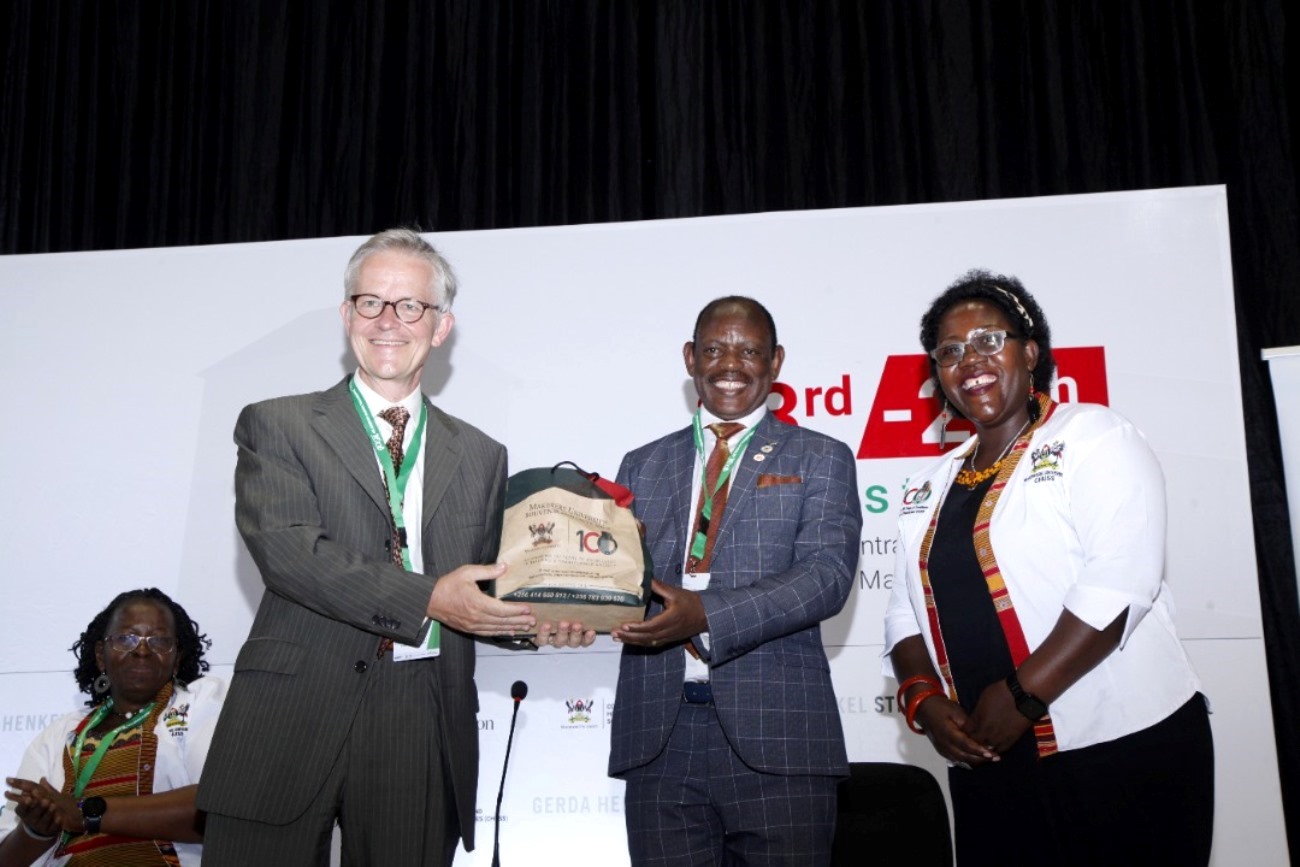 The Vice Chancellor, Prof. Barnabas Nawangwe (2nd R) presents an assortment of Mak Souvenirs to German Ambassador, H.E. Matthias Schauer (2nd L) as Principal CHUSS, Prof. Josephine Ahikire (R) and Prof. Grace Bantebya (L) applaud on 23rd August 2022, Yusuf Lule Central Teaching Facility Auditorium, Makerere University.