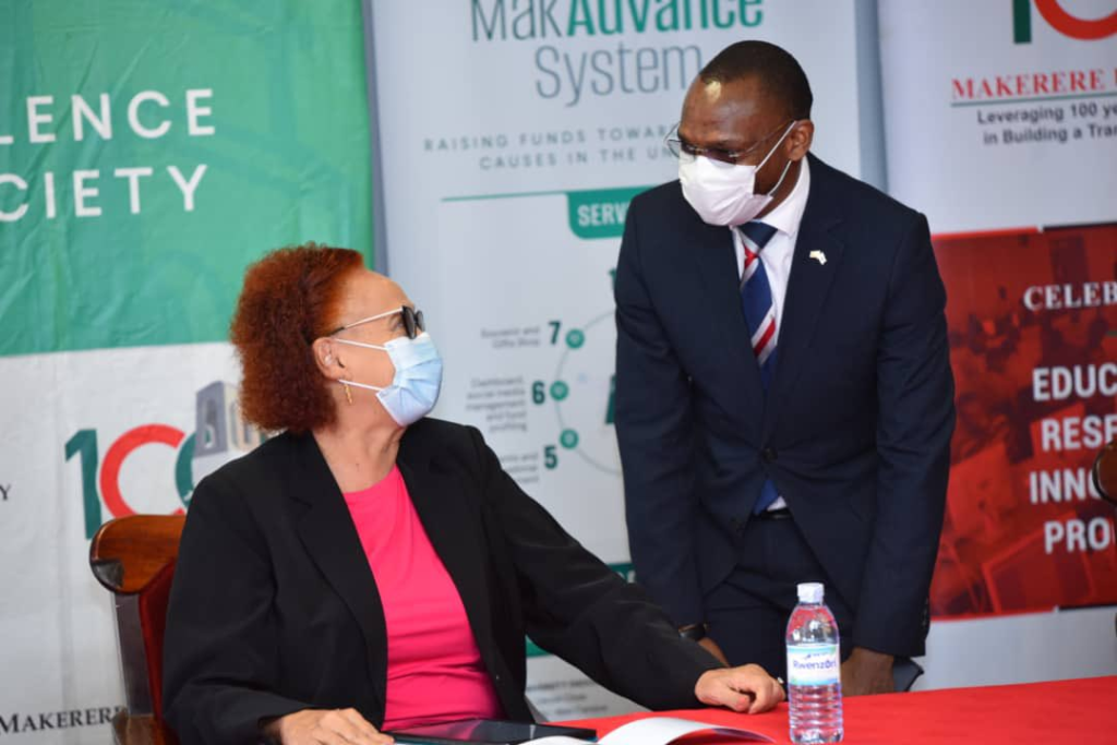 Prof. Umar Kakumba (R) shares a light moment with Prof. Margaret Kigozi (L) at the event.