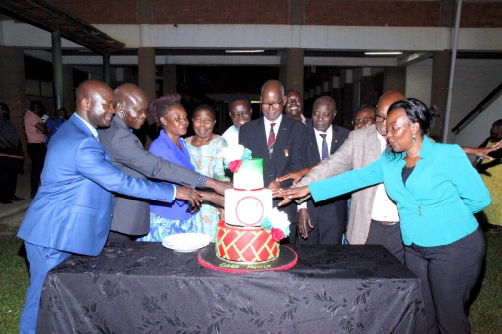 Retirees join the Principal and Deputy Principal CAES to cut cake in celebration of their service to Makerere.