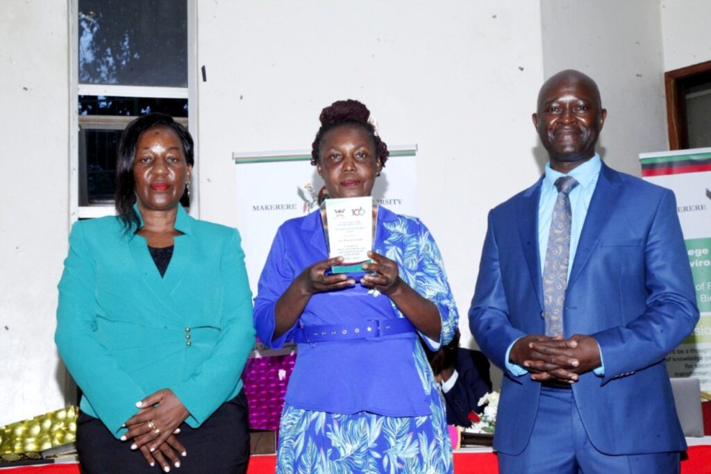 A retired member of staff receiving an award from the Principal CAES. On the Left is the Deputy Principal, Prof. Yazidhi Bamutaze.