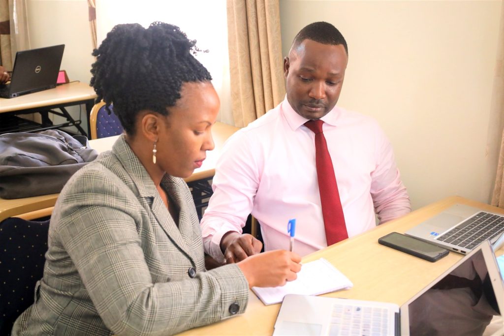 Dr. Allen Kabagenyi (L) and a participant take part in workshop activities. 