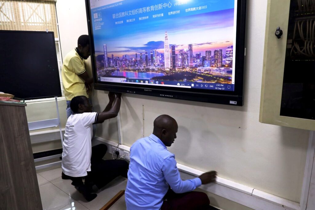 Mak-CoCIS IT experts Nicholas Betungye, Badru Ssekumba and Baluku Herbert make final touches during the setup of the Smart Classroom.