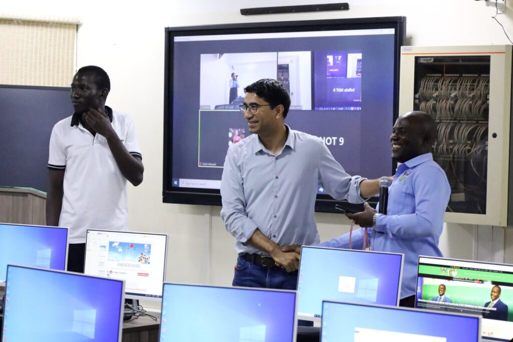 Hassan Adeel (C) congratulates local expert Baluku Herbert (R) on the job well done as Badru Ssekumba (L) observes.