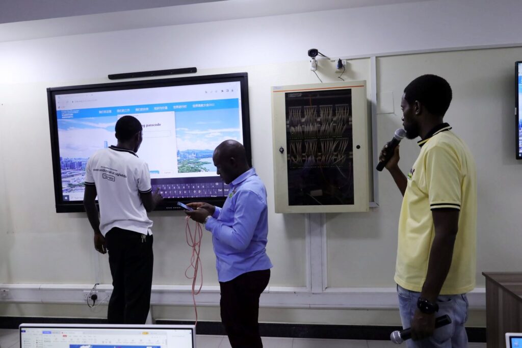 Mak-CoCIS IT experts Badru Ssekumba, Baluku Herbert and Nicholas Betungye testing the smart classroom system during the final connectivity.