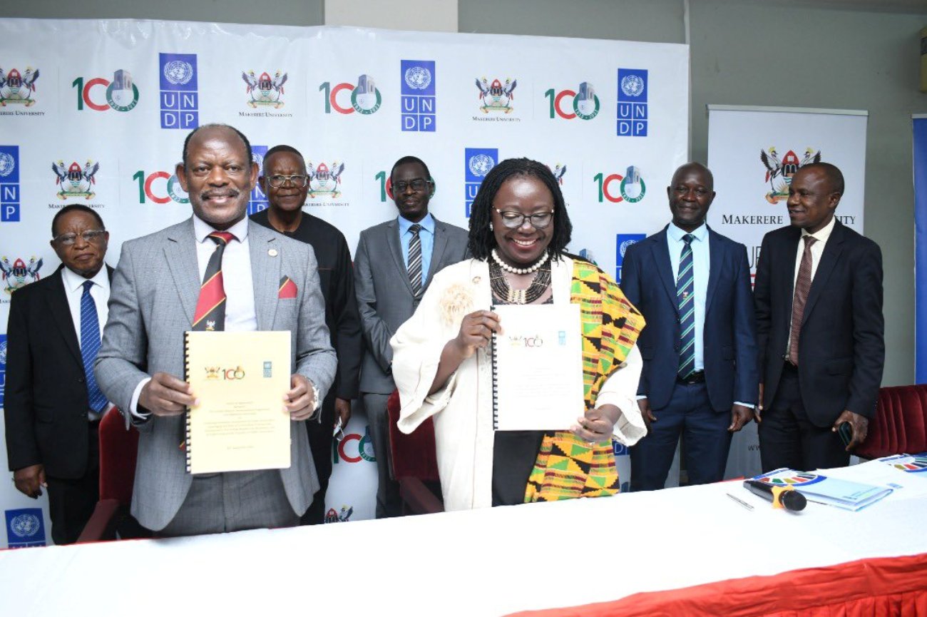 The Makerere University Vice Chancellor, Prof. Barnabas Nawangwe (Left) and the UNDP Resident Representative for Uganda Ms. Elsie Attafuah (Right) show off the signed MoU on 20th September at Makerere University. Second row are: Makerere Chancellor, Prof. Ezra Suruma (Left), Prof. Ephraim Kamuntu (2nd Left), Prof. Eria Hisali (Right), Associate Prof. Yazidhi Bamutaze (2nd Right) and other officials.
