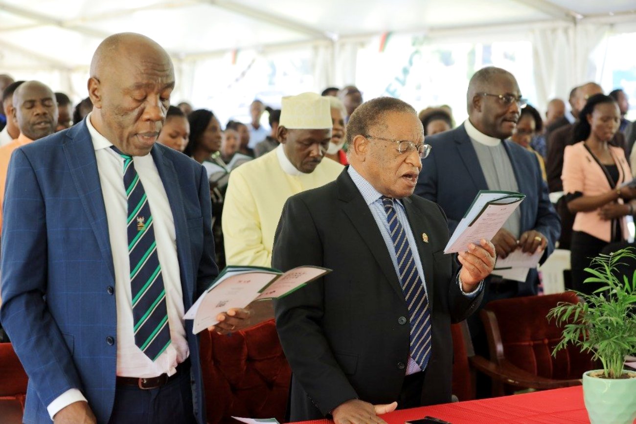 The Chancellor, Prof. Ezra Suruma (R) and DVCFA, Prof. Henry Alinaitwe (L) join the congregation in song during the Makerere@100 National Thanksgiving Prayer, 2nd September 2022, Freedom Square, Makerere University.