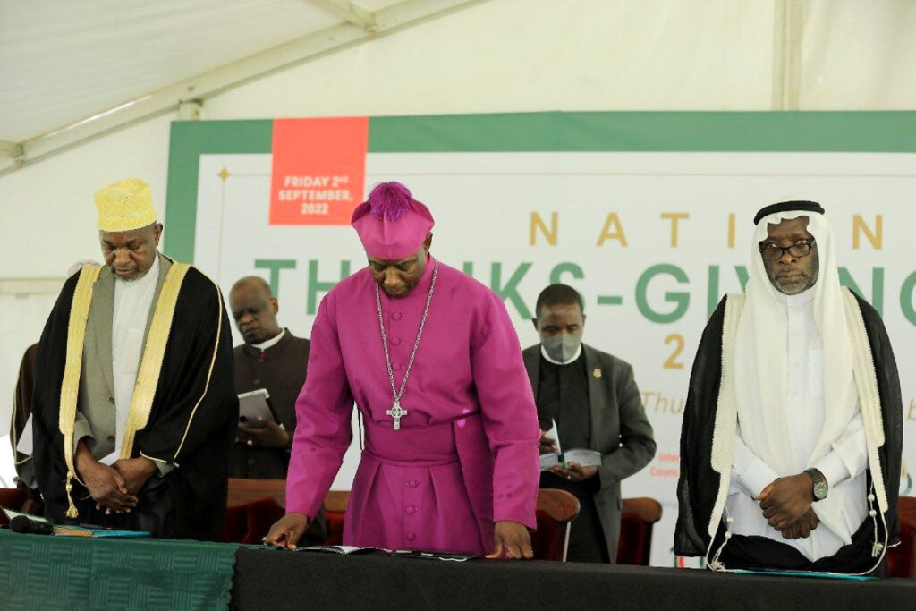 Archbishop of Church of Uganda (C) flanked by other religious leaders bows his head in prayer. 