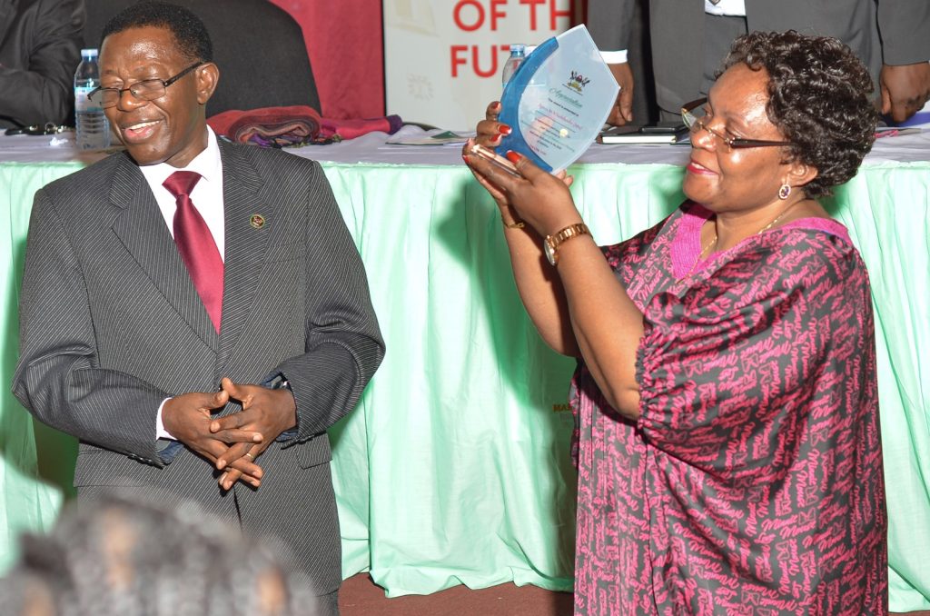 Mrs. Ssekiboobo receives her plaque.