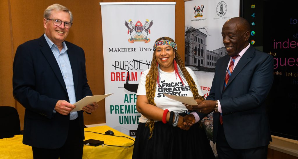 Prof. Henry Alinaitwe (R) and Prof. Tore Sætersdal (L) present a certificate to one of the participants (C) during the award ceremony.