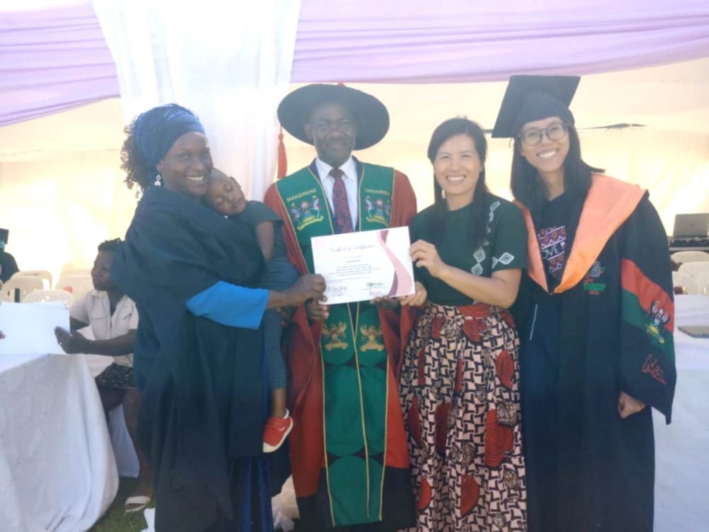 Dr. Twine Bananuka (2nd L), Sara Liu (2nd R) and Elle Yang (R) present a certificate to one of the graduands (L). 