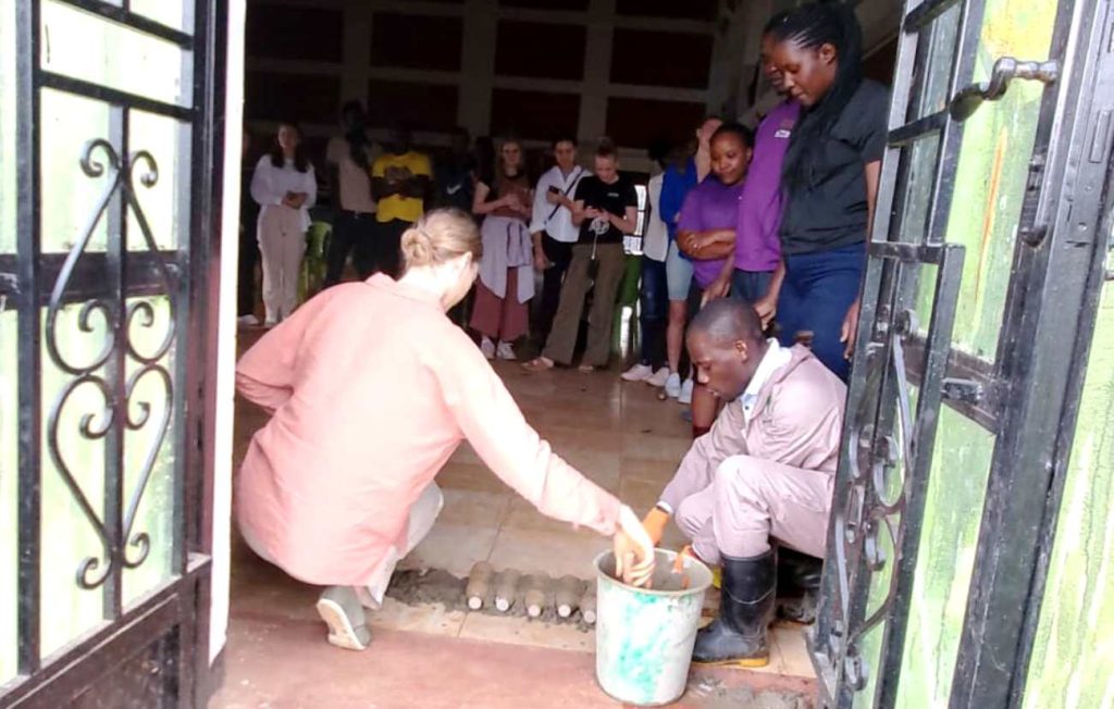 Students learn the technique of building houses using discarded plastic bottles. 