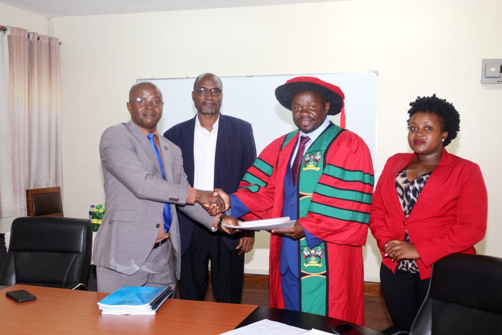 Prof. Bruno Yawe (2nd L) and a representative from the Internal Audit Directorate (R) witness as Prof. Edward Bbaale (L) hands over the Deanship to Prof. Ibrahim Okumu Mike (2nd R).