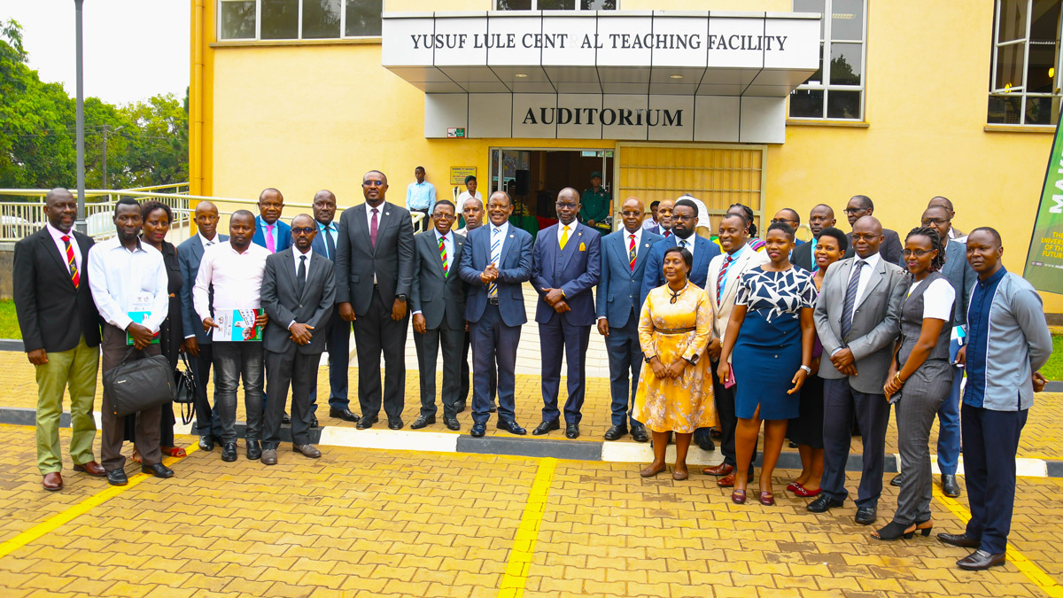 Government Chief Whip Hon. Hamson Obua (in a yellow tie) flanked by Vice Chancellor Prof. Barnabas Nawangwe (on his left) and Prof. Edward Bbaale (on his right) join Members of Management and leadership the PhD Fellows after the opening ceremony of the Annual Doctoral Convention 2023 held at the Yusuf Lule Auditorium on 28th February 2023.