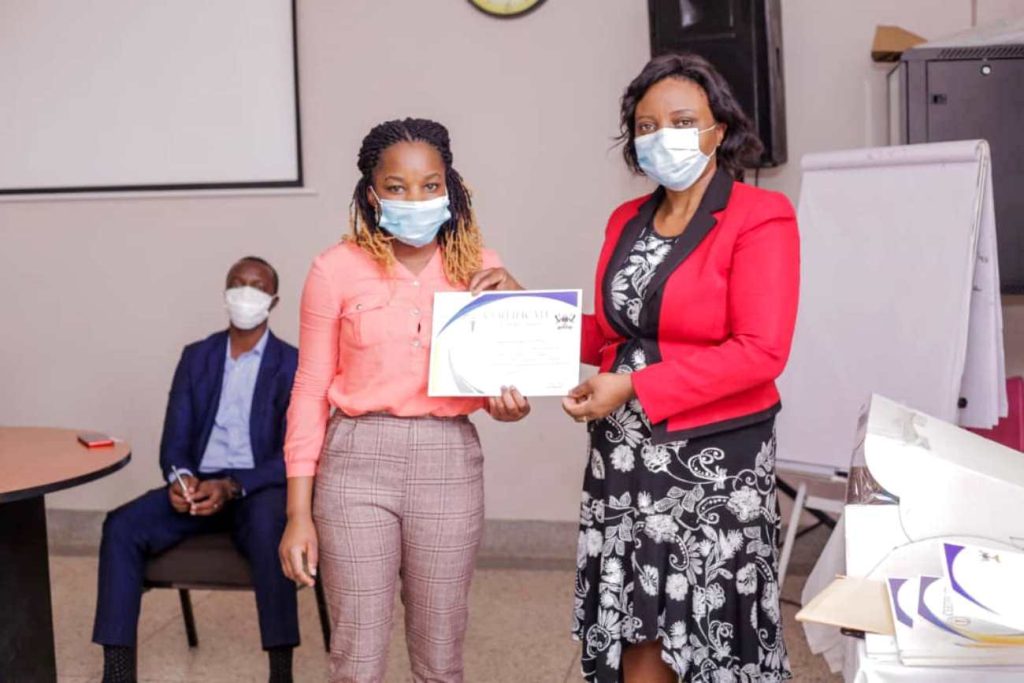 Nabbanja receives a leadership certificate from Dr. Damalie Nakanjako, Professor of Medicine, and Principal of the College of Health Sciences.