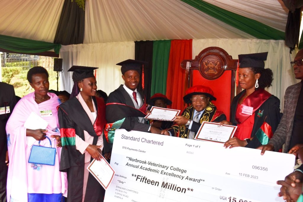 The Best Veterinary Medicine Students receive a dummy check from the Chancellor, Prof. Ezra Suruma.