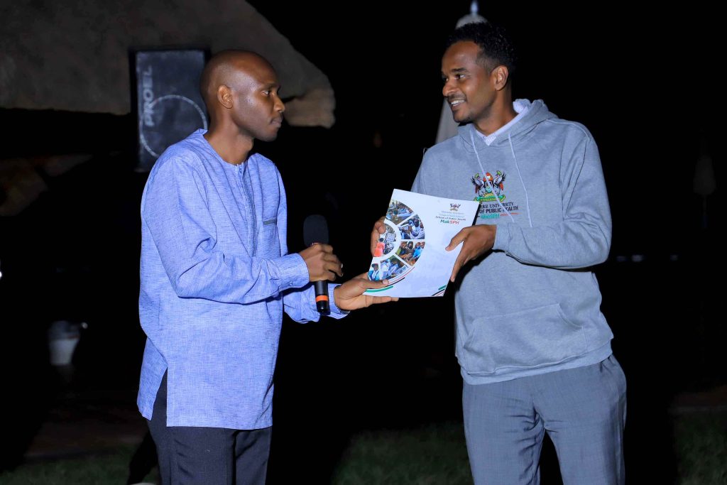 Dr. David Musoke (L) handing over the grant award to Mr. Abdullah Ali Halage (R).