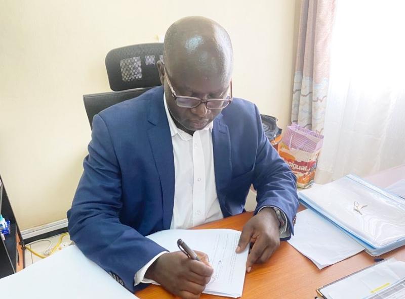 Incoming Dean, Dr. Justus Twesigye signs the handover report in the Deans office.