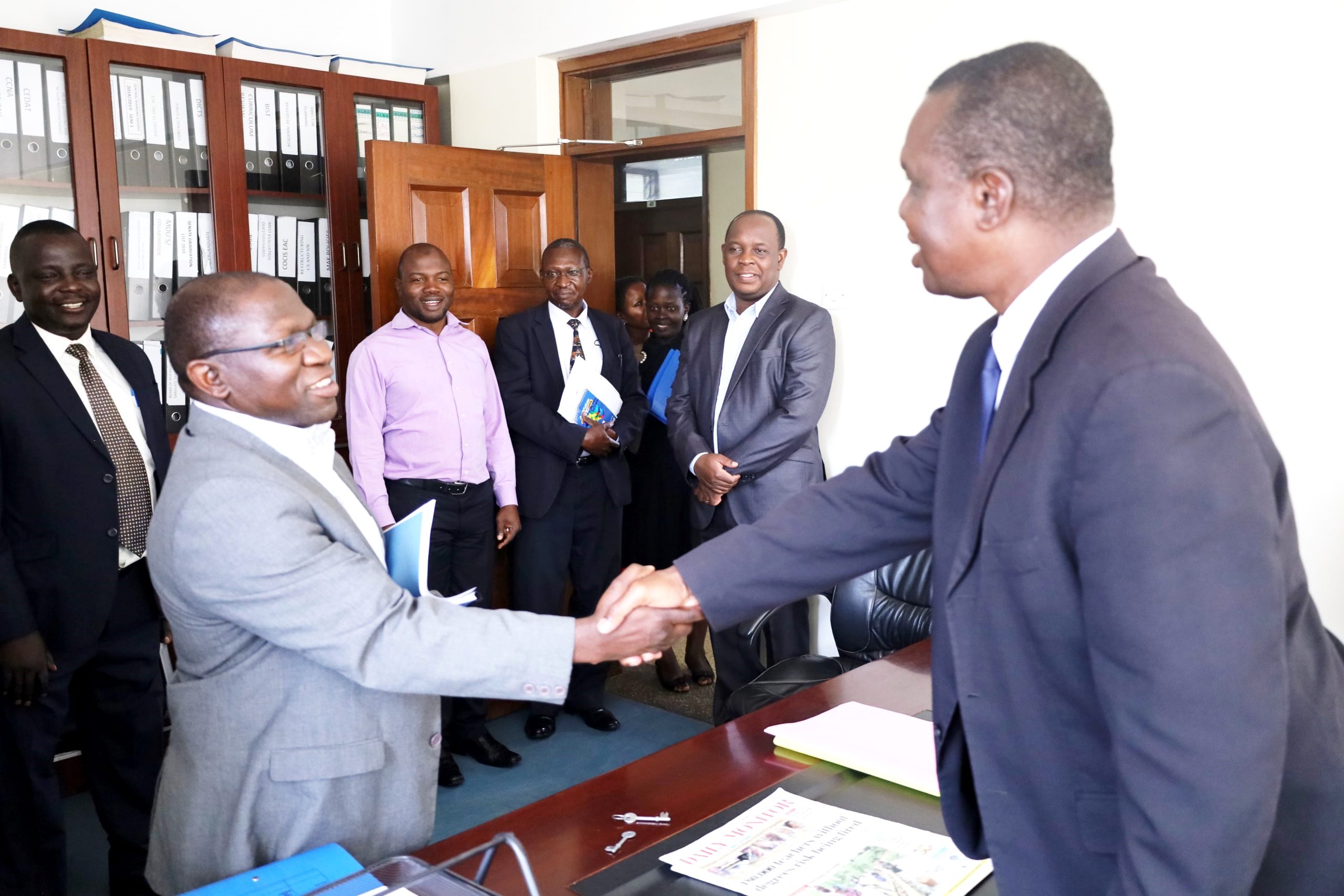 Assoc. Prof. Gilbert Mayiga (R) shakes hands with Dr. Joseph Balikuddembe during the handover ceremony of the SCIT Deanship on 30th November 2022 at CoCIS, Makerere University.