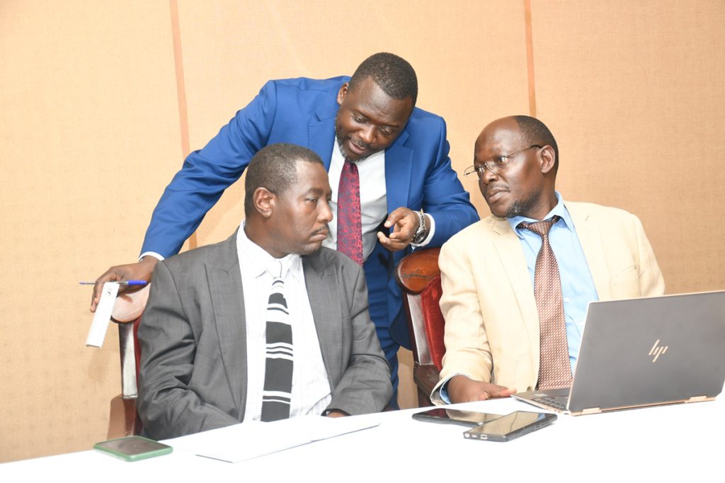 L-R: Mr. Evarist Bainomugisha, Mr. Yusuf Kiranda and Mr. Lubowa Gyaviira consult during the meeting. 