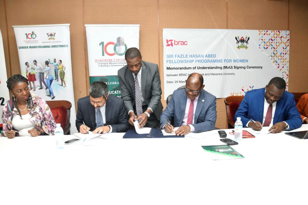 Seated: Prof. Barnabas Nawangwe (2nd R), Mr. Shameran Abed (2nd L), Ms. Rudo Kayombo (L) and Mr. Yusuf Kiranda (R) assisted by Mr. Hudson Musoke (Standing) sign the MoU.