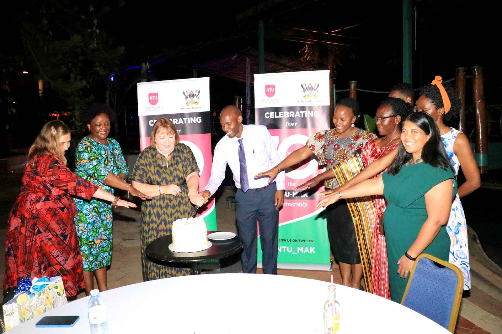 The NTU-Mak partnership leads Prof. Linda Gibson (3rd L) and Dr. David Musoke (4th L) are joined by the Dean MakSPH, Prof. Rhoda Wanyenze (2nd L) and other officials to cut cake during the celebration of 10 years of collaboration in December 2022.