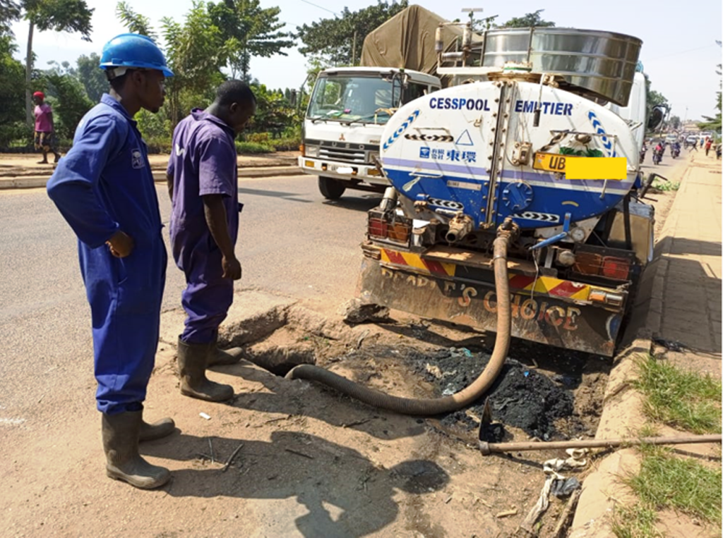 Two sanitation workers without all the necessary PPE required during the emptying of a blocked wastewater channel in one of the regions.