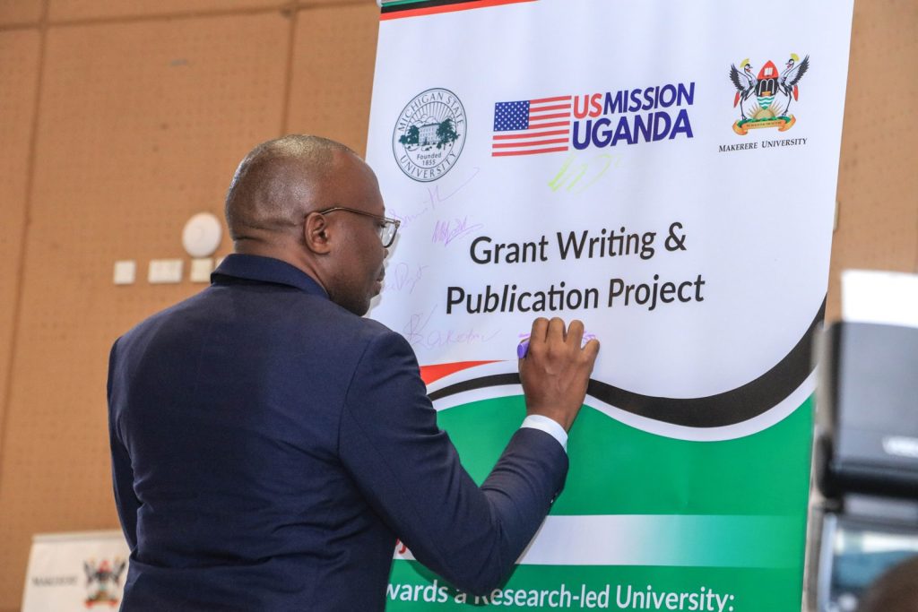 Professor Ronald Bisaso, CEES, a Co-PI of the Grant Writing Project signs the banner at the launch of the project.