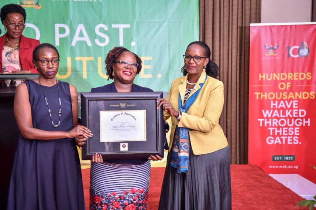 Juliet Nsibambi Kasujja and Violet Nsibambi receive the Certificate of Recognition on behalf of their late father Rt. Hon. Prof. Apolo Robin Nsibambi from Mrs. Lorna Magara (Right). 