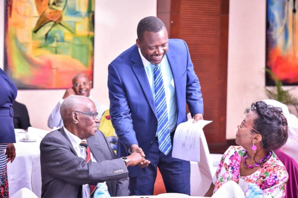 Mr. Yusuf Kiranda (Centre) interacts with Hon. Mathew Rukikaire (Left) and Mrs. Christine Kiganda (Right) during the celebrations.