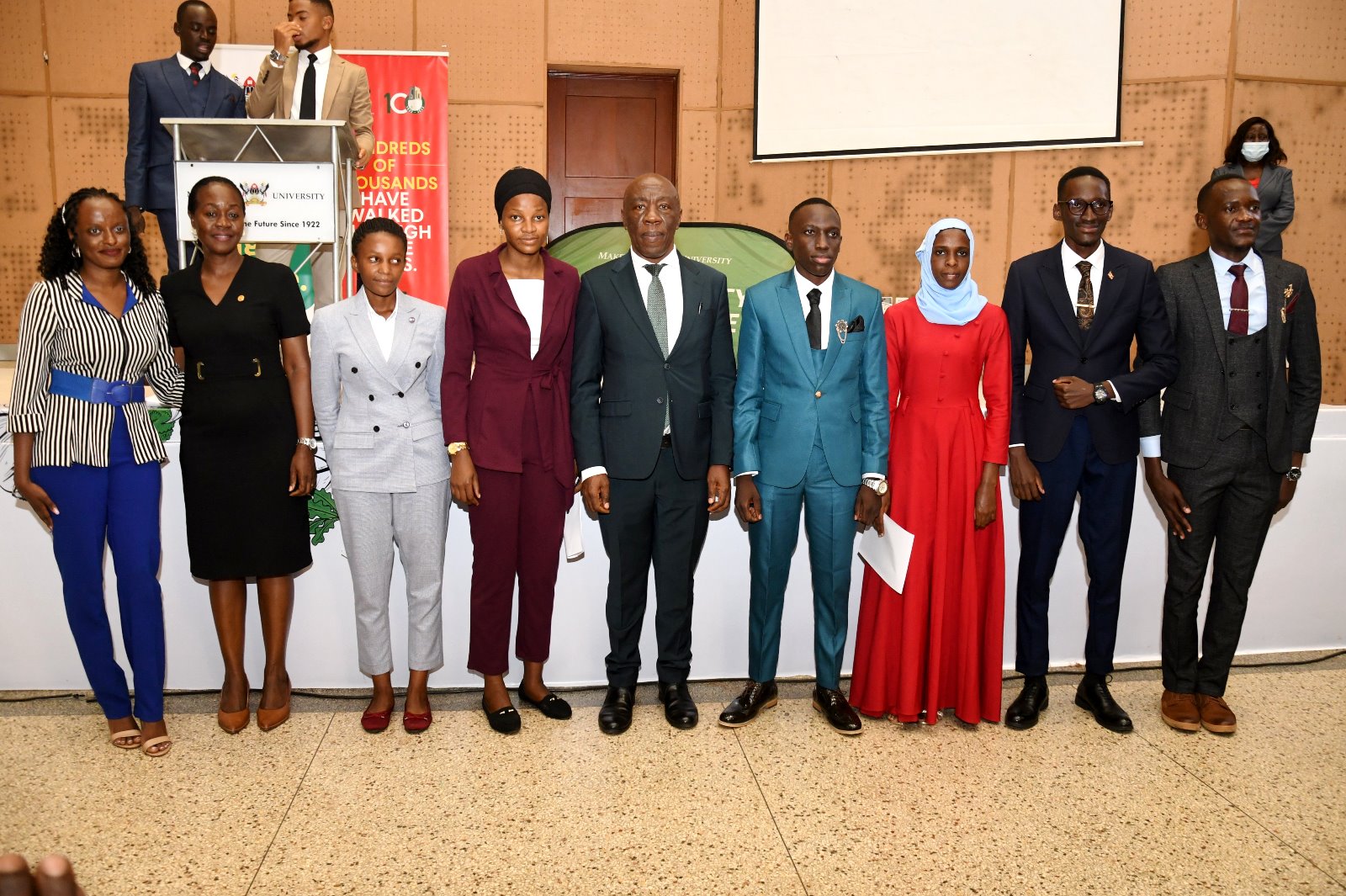 The DVCFA-Prof. Henry Alinatwe (Centre) and Dean of Students-Mrs. Winifred Kabumbuli (2nd Left) flanked by 89th Guild President-H.E. Robert Maseruka (4th Right), His Vice-H.E. Mariat Namiiro (3rd Right) and other Cabinet Members after the Swearing-in Ceremony on 24th April 2023, Yusuf Lule Auditorium, Makerere University.